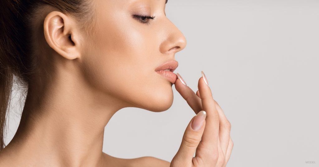 Woman with full lips after lip fillers. (Model)